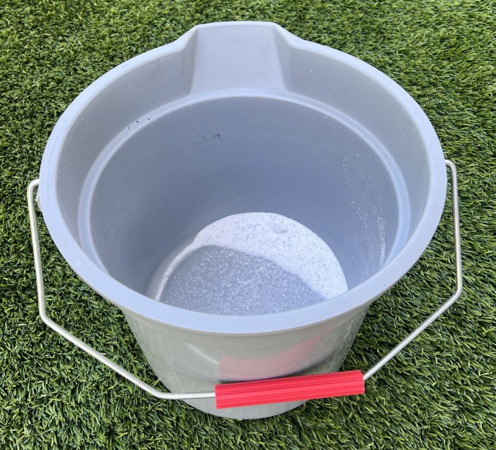 Bucket with laundry soap for cleaning hats