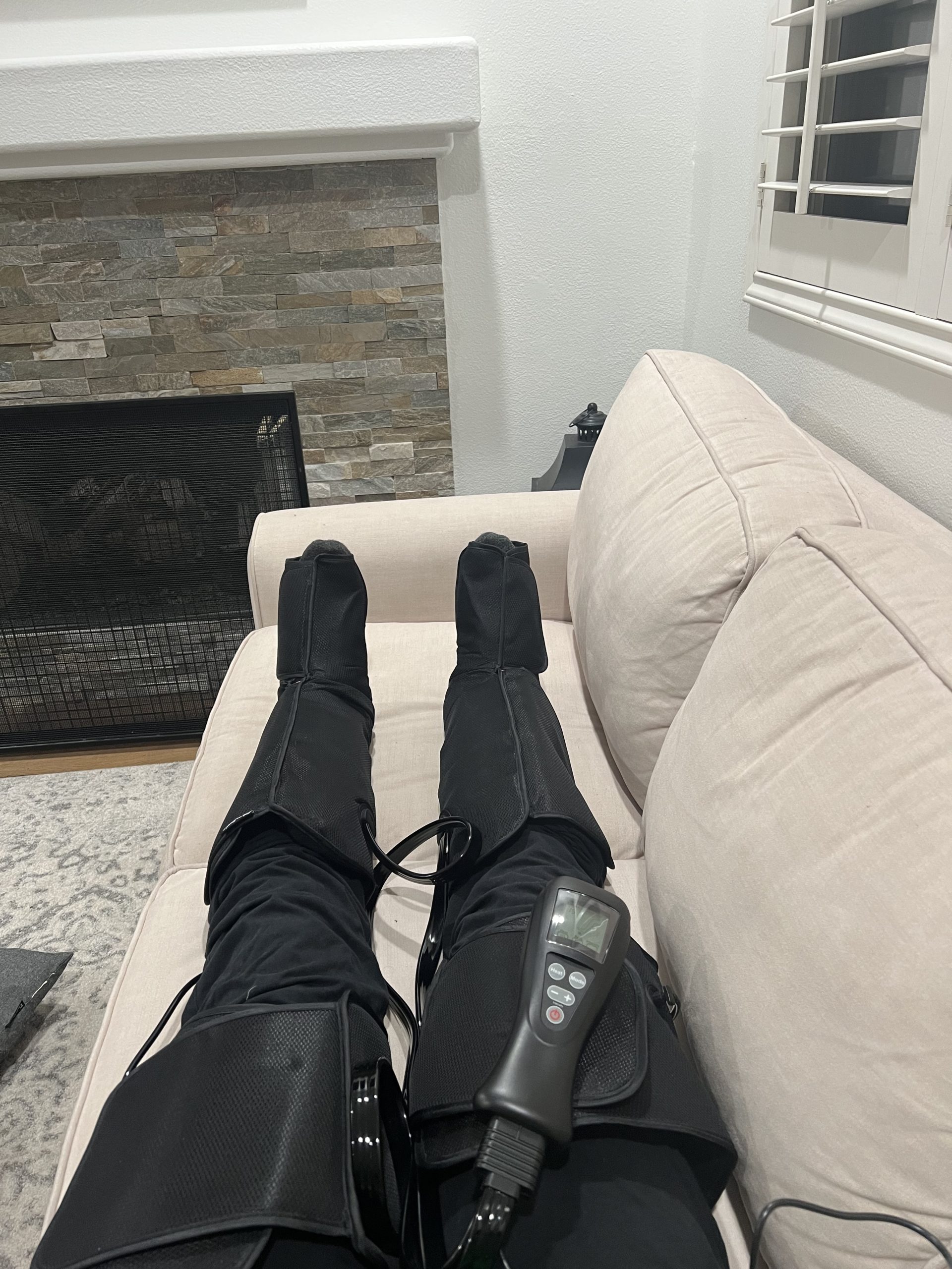 using a compression leg massager on a couch